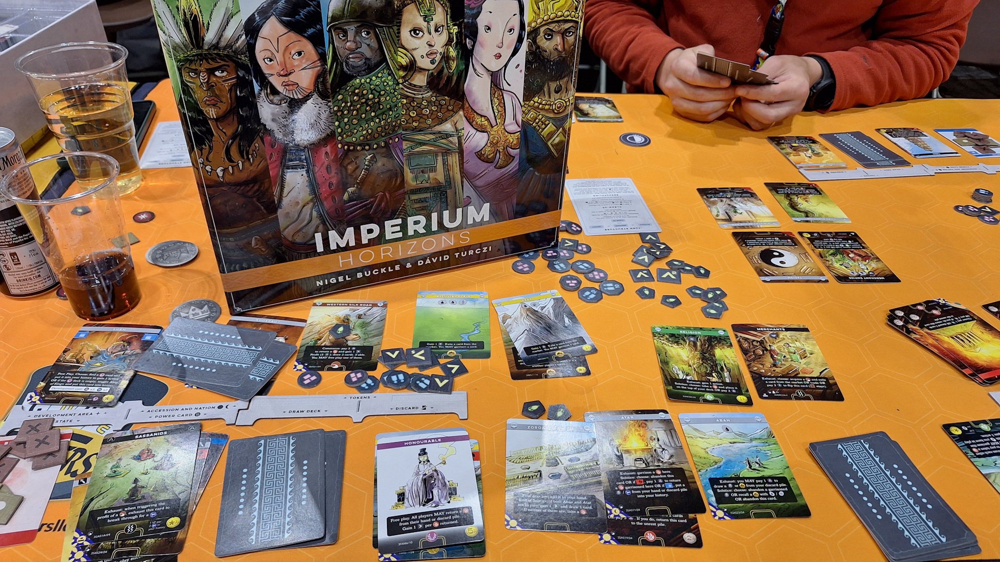 Imperium Horizons, dozens of cards are lain out across a tabletop with the game box slammed in the middle of them